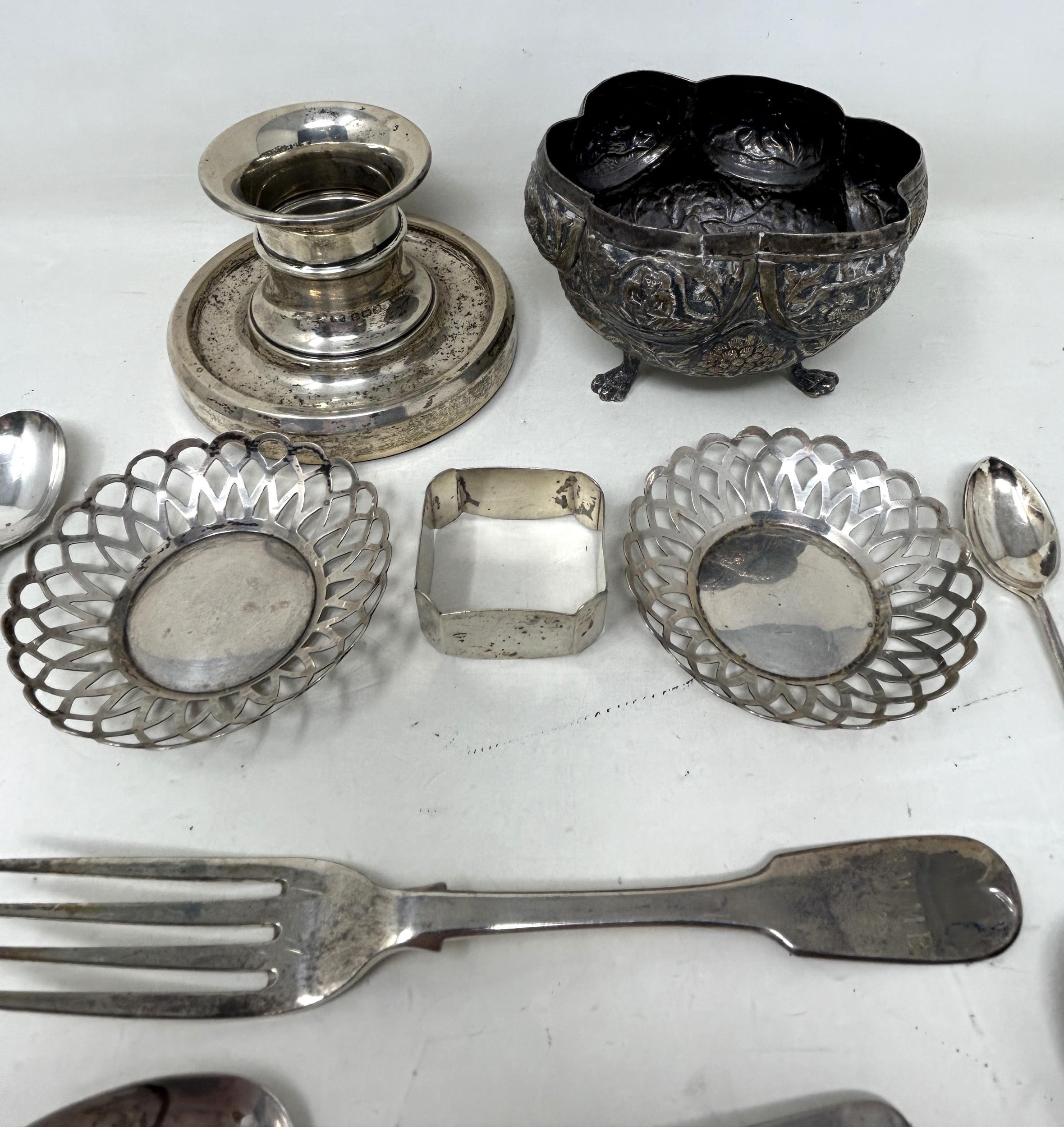 An Indian silver coloured metal sugar bowl, assorted teaspoons, a napkin ring, a pair of pierced