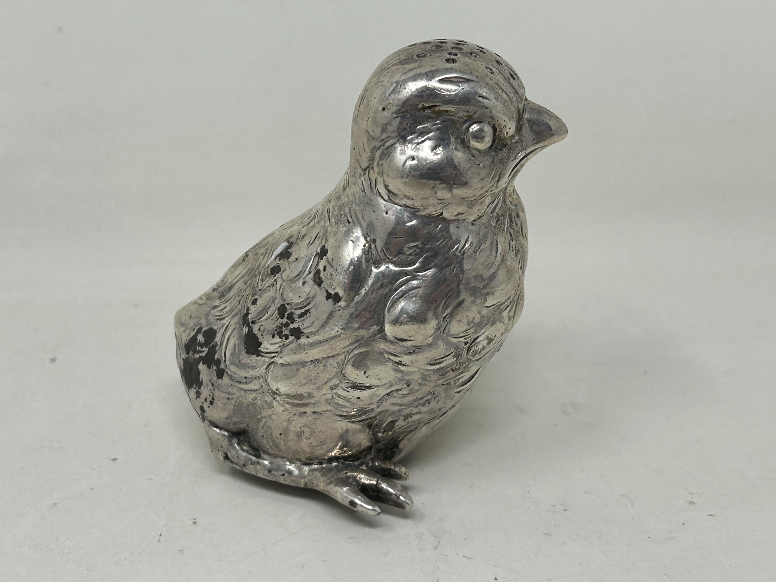A novelty Continental silver coloured metal pepper, in the form of a chick, import marks for