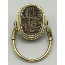 A yellow coloured metal hinged ring, inset with a scarab, the undersigned with hieroglyphics, ring