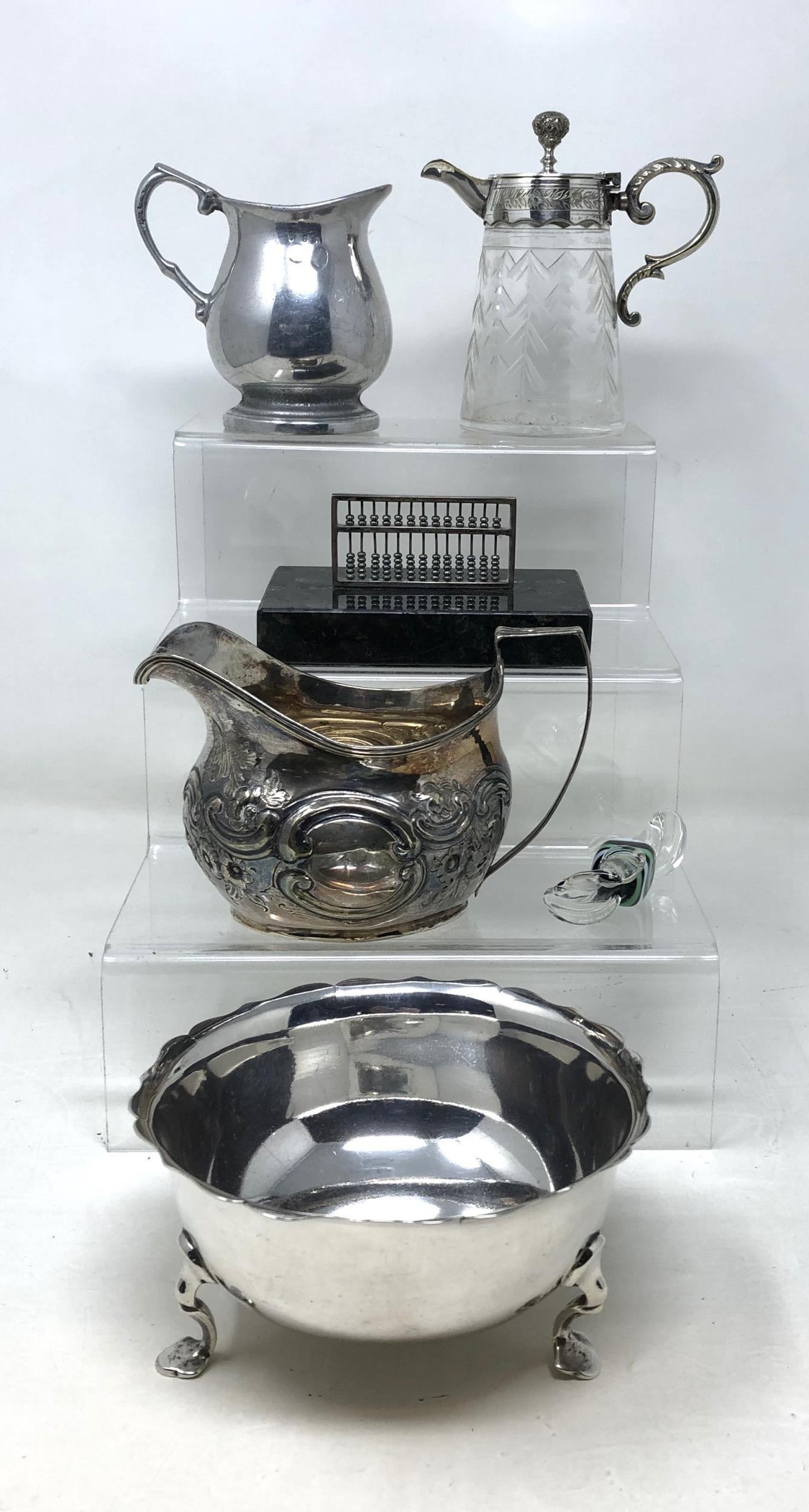 A George V silver sugar bowl, 5.1 ozt, two silver plated cream jugs, a silver coloured metal abacus,