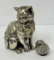 A novelty silver jar and cover, in the form of a cat, 7 cm high, and a small silver chick, 2 cm high