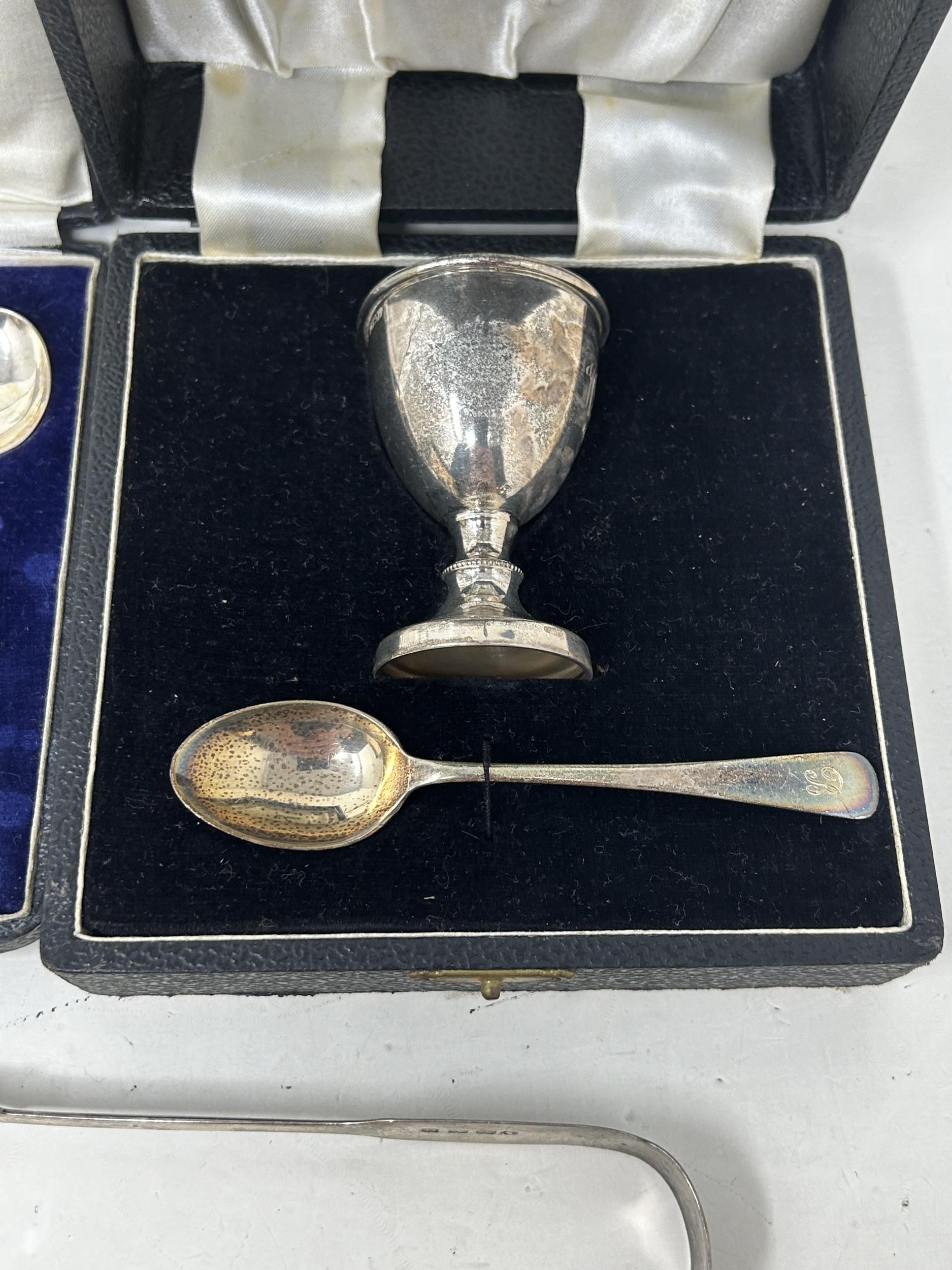 A fiddle pattern spoon, another, a napkin ring, a pair of sugar tongs, an egg cup and spoon, - Image 3 of 7