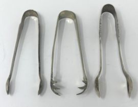 A pair of Edward VII sugar tongs, 1908, another pair, 1943, and a silver coloured metal pair (3)