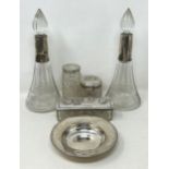 A silver dish, 2.2 ozt, a pair of silver mounted engraved glass perfume bottles, and three silver