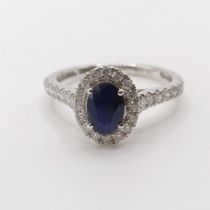 An 18ct white gold, sapphire and diamond cluster ring, ring size M