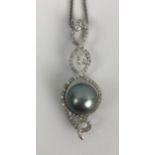 An 18ct white gold, pearl and diamond pendant, on a chain