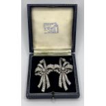 A diamond double clip bow brooch, set with baguette and brilliant cut diamonds, 7 cm wide, central
