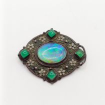 An Arts and Crafts silver coloured metal, opal, green stone and enamel brooch, by Jean Bassett