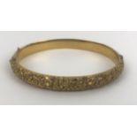 A Victorian 15ct gold hinged bangle, engraved with two sets of monogrammes and dated 21 11 89, 12.