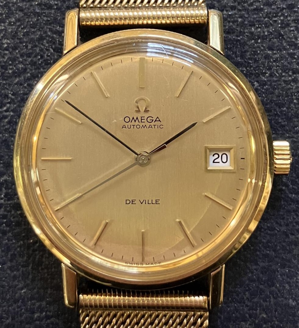 A gentleman's 9ct gold Omega Automatic De Ville wristwatch, with baton indices and date, on a 9ct