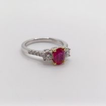 An 18ct white gold, oval ruby and RBC diamond trilogy ring with diamond shoulders, ruby 0.89ct,