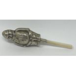 A silver coloured metal and mother of pearl novelty baby's rattle, in the form of a fireman