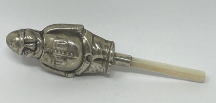 A silver coloured metal and mother of pearl novelty baby's rattle, in the form of a fireman