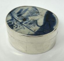 A Continental silver coloured metal oval box, top inset with blue and white ceramic panel
