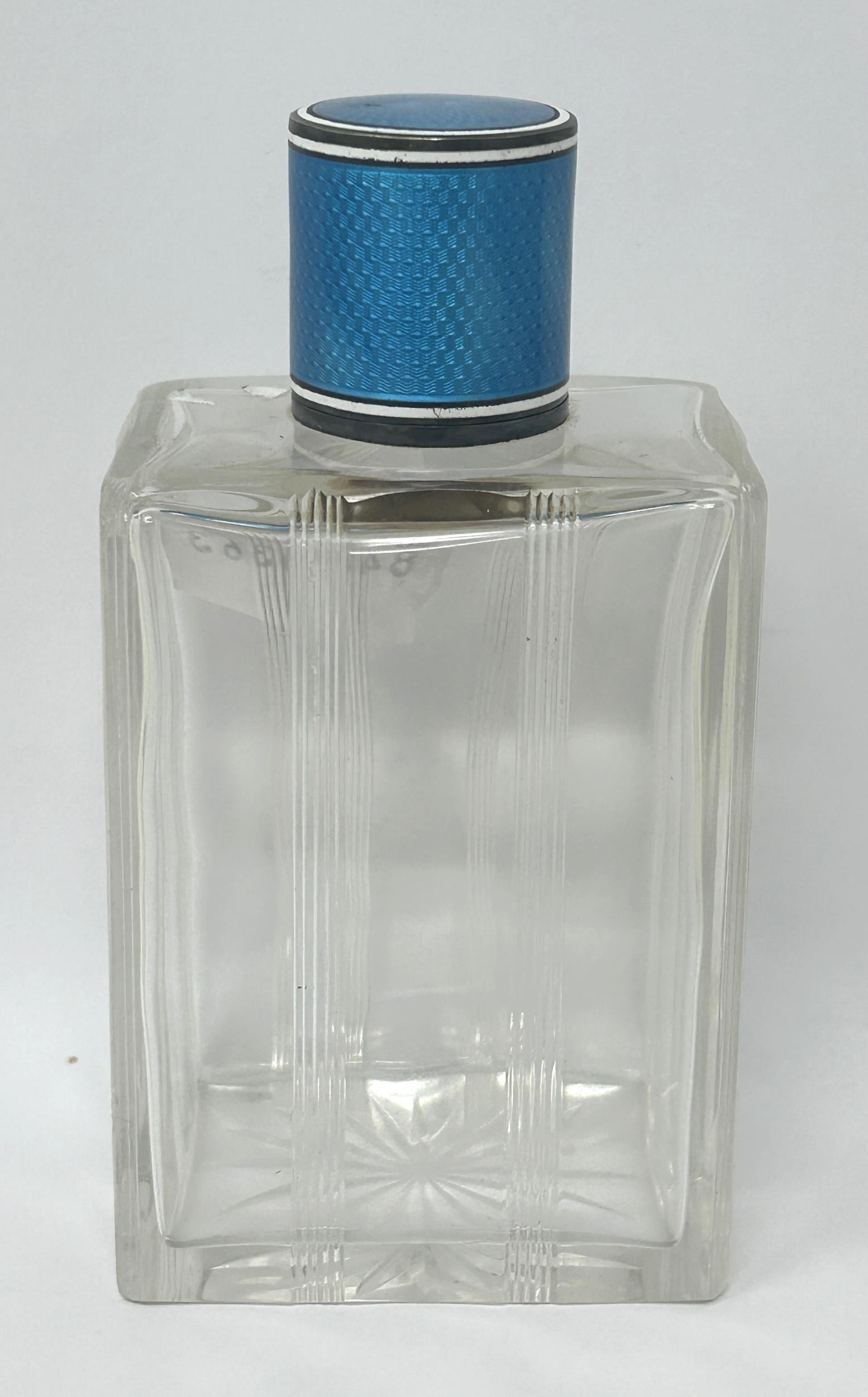 A silver, blue and white enamel topped glass perfume bottle, 12 cm high