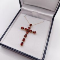 An 18ct yellow gold cross necklace, set with 5.00ct pear-shaped garnets, boxed