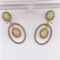 A pair of silver-gilt chandelier style articulated drop earrings, each set with two cabochon opals