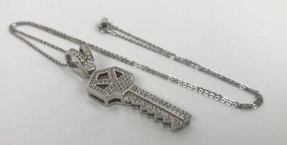 A silver key pendant, pave-set with over 100 white round cubic zirconia