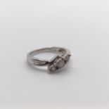 A 9ct white gold and graduated diamond trilogy ring, in a twist mount, diamonds 0.20ct, ring size