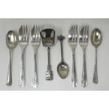 A Continental silver coloured metal sugar scoop, a set of four silver plated cake forks, two