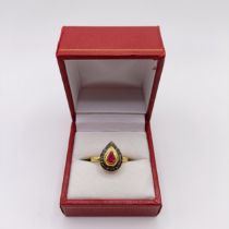 A pear shaped ring, set with pear shaped ruby and halo of R/C diamonds set in gold-plated silver,