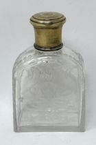 An engraved glass perfume bottle, with gilt metal cap, 12 cm high
