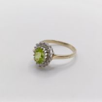 A 9ct yellow and white gold cluster ring, set with an oval-cut peridot and RBC diamonds, size N 1/2