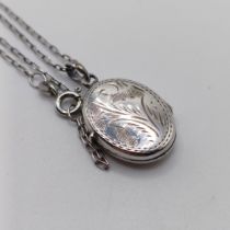 A silver coloured metal oval locket, on a chain