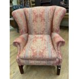 A wingback armchair, on mahogany legs