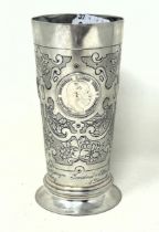 A Continental silver coloured metal beaker, inset with coins, .800 6.4 ozt
