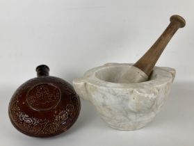 A stoneware hot water bottle, 18 cm diameter, and a pestle and mortar (3)