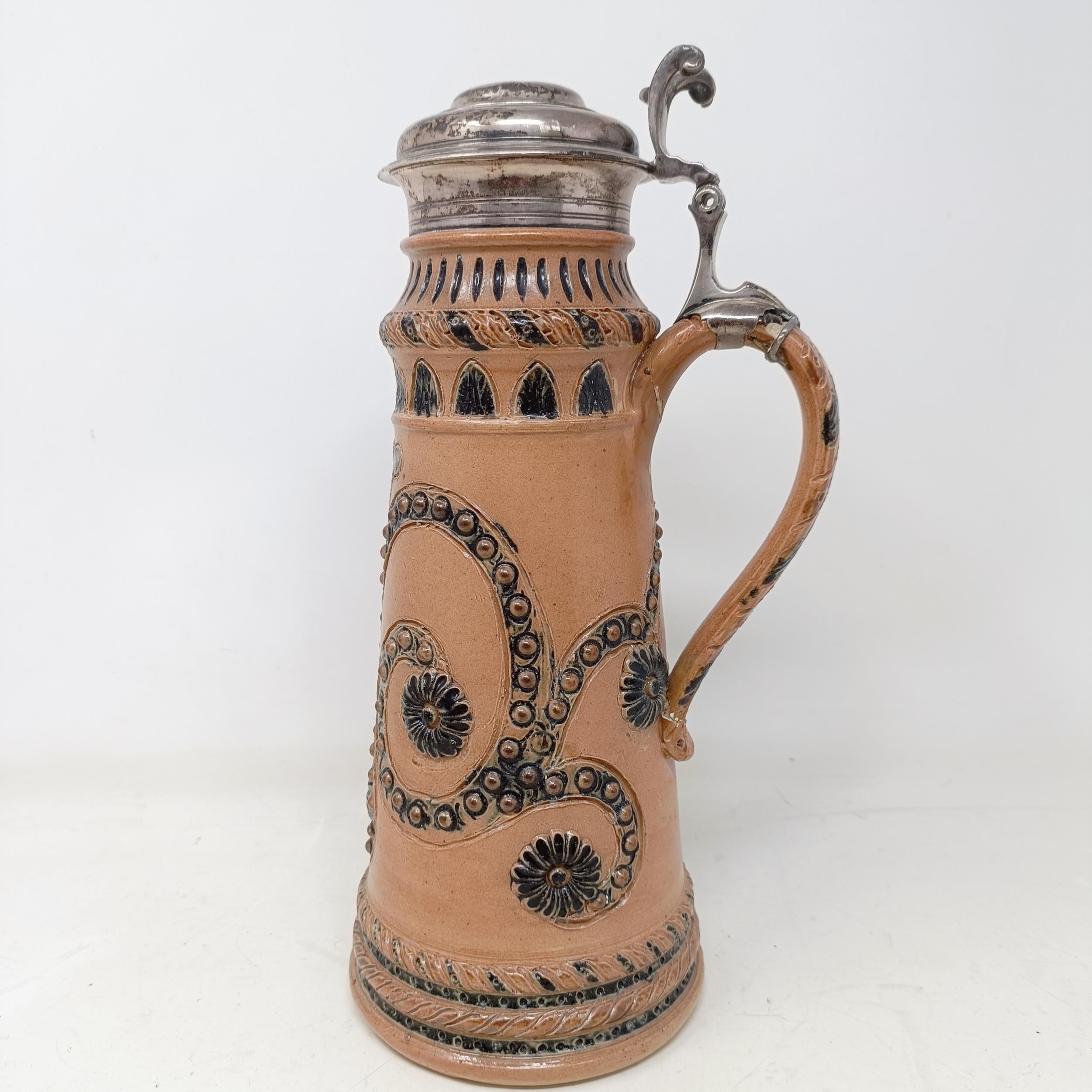 A Doulton Lambeth stoneware flagon, with a silver mount, London 1866, 30 cm high Handle crudely
