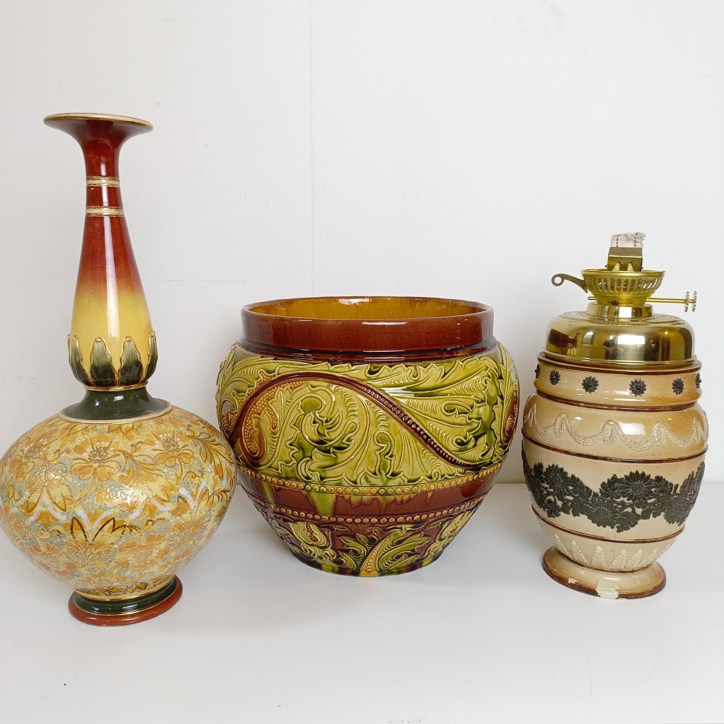 A Royal Doulton vase, decorated with flowers, 43 cm high, a jardinière, 29 cm diameter, and an oil