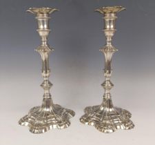 A pair of mid 18th century cast silver candlesticks, on spreading shaped circular bases, with