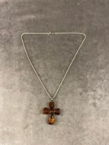 A Baltic Amber cross set in silver on silver chain