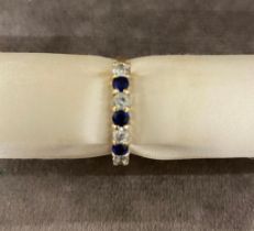 A 15 carat gold ladies ring set with diamonds and sapphires 2.6 grams, size O