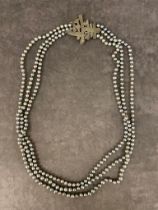 A large antique Tahitian pearl necklace with a white metal brooch clasp