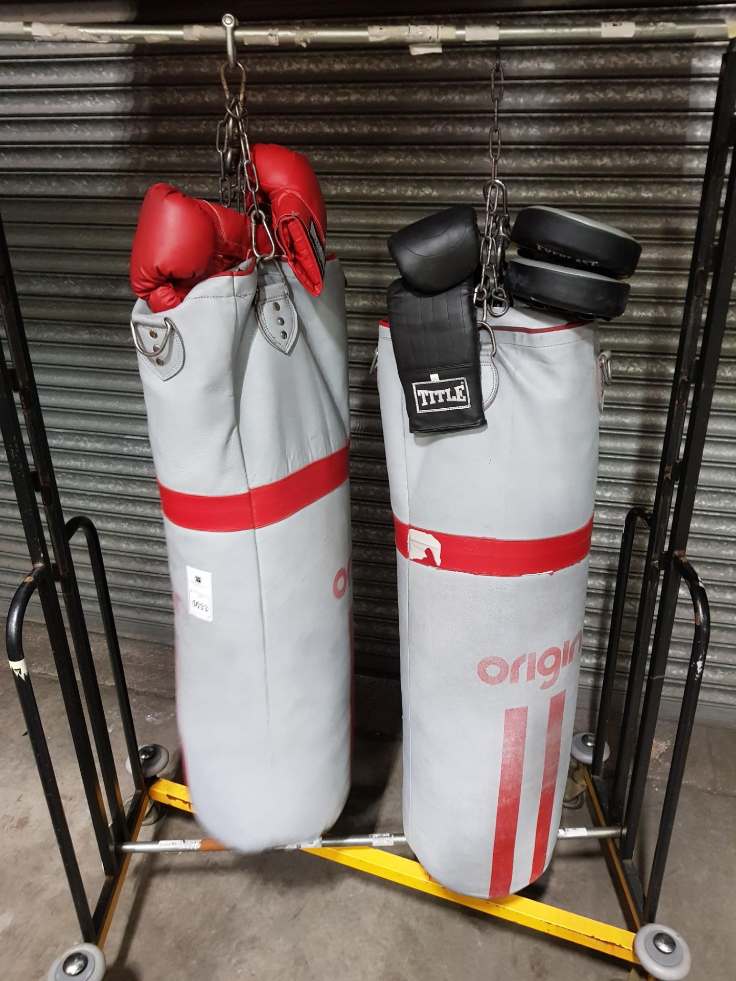 2 X HEAVILY USED ORIGIN GREY 4 FT LEATHER PUNCH BAGS WITH CHAINS / 2 PAIRS OF BOXING GLOVES AND 1