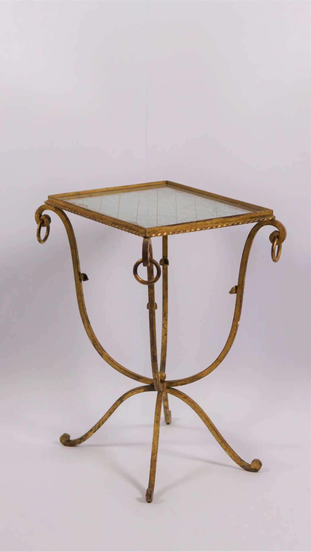 A wrought iron end side table with a gold glomyized mirrored glass top. Mid 20th Century