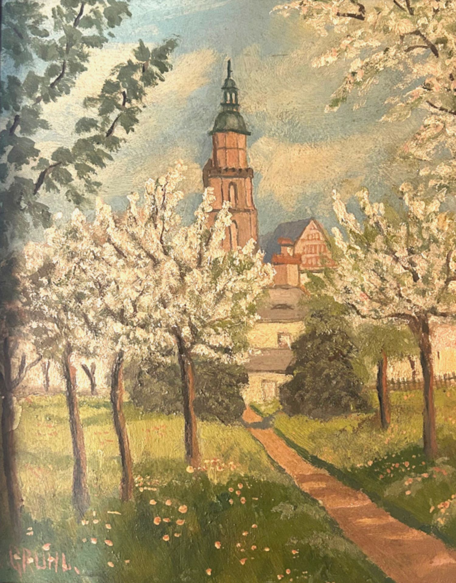 Blühende Apfelbäume vor Stadtkulisse mit Kirchturm