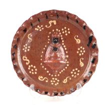 A slipware dish with pie crust rim, the central relief depicting Moorish type religious figures,