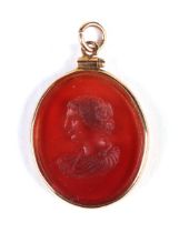 A Grand Tour style glass intaglio cut pendant depicting a bust portrait of a neo-classical figure,