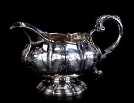 A George IV silver milk jug decorated with flowers and foliate sprays, London 1825 and maker's