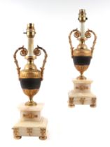 A pair of gilt metal table lamps in the form of classical vases, on marble bases, 39cms high.