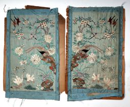A pair of 19th century silk embroidered panels depicting birds amongst flowering foliage, on a
