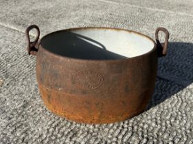 A cast iron and enamel two-handled two-gallon cooking pot by Izons & Co., 34cms wide. Condition