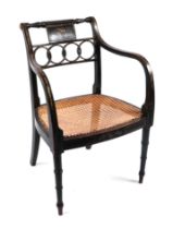An early 19th century Regency period black lacquer and gilt open armchair with reeded seat and