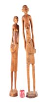 An African tribal fertility carved wooden figure of a lady and child, 128cms high; together with