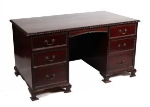 A George III style mahogany kneehole pedestal desk, the rectangular top with carved rope twist edge,