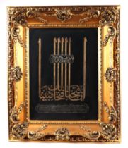 An Islamic bi-metal panel with script, 29 by 40cms, in a swept gilt frame.